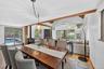 Dining room featuring light wood finished floors, a wood stove, and a wall mounted AC