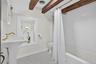 Full bathroom featuring beam ceiling, shower / bathtub combination with curtain, and tile patterned floors