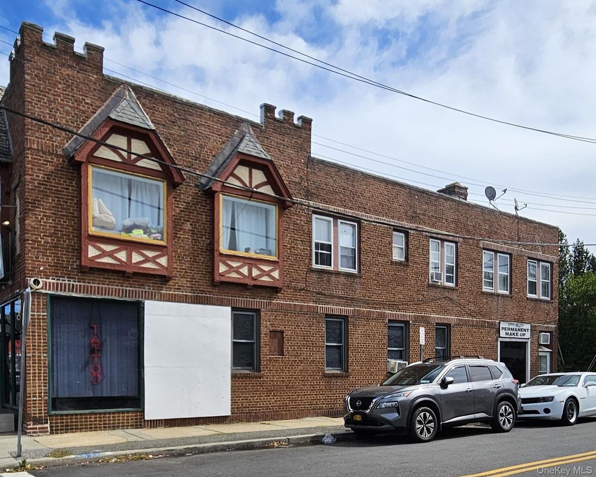 View of front facade featuring brick siding and a chimney