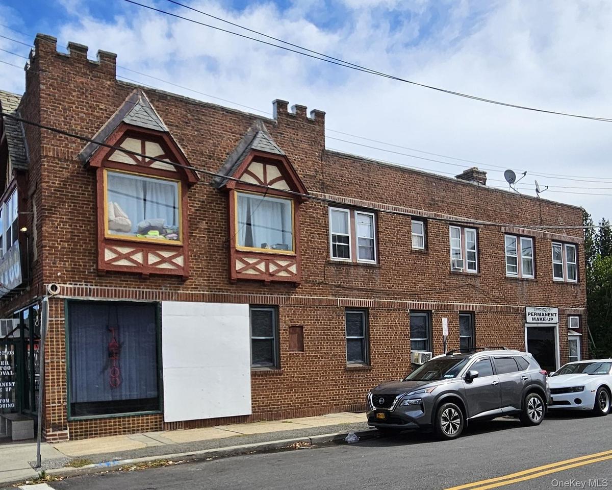 View of front facade featuring brick siding and a chimney