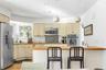 Kitchen with wood counters, decorative light fixtures, sink, stainless steel appliances, and cream cabinets