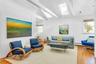 Living room with lofted ceiling with skylight, hardwood / wood-style floors, and a wealth of natural light