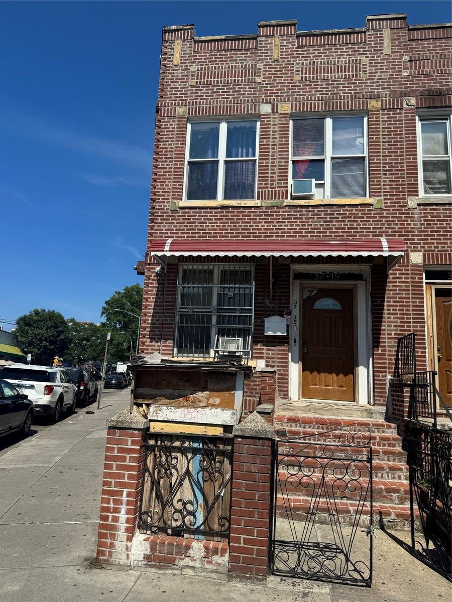 View of property with brick siding and cooling unit