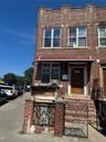 View of property with brick siding and cooling unit
