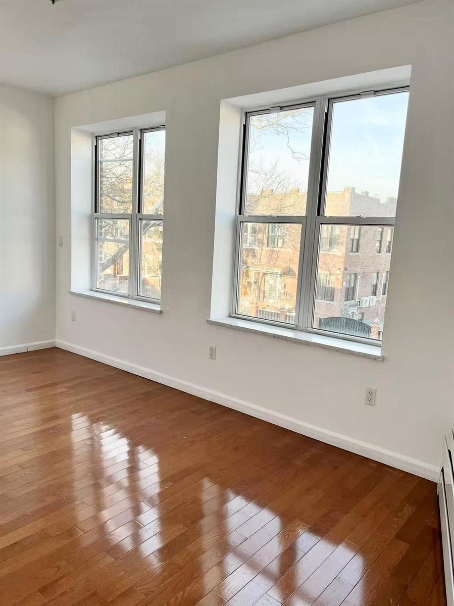 Spare room featuring wood-type flooring and baseboard heating