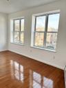 Spare room featuring wood-type flooring and baseboard heating