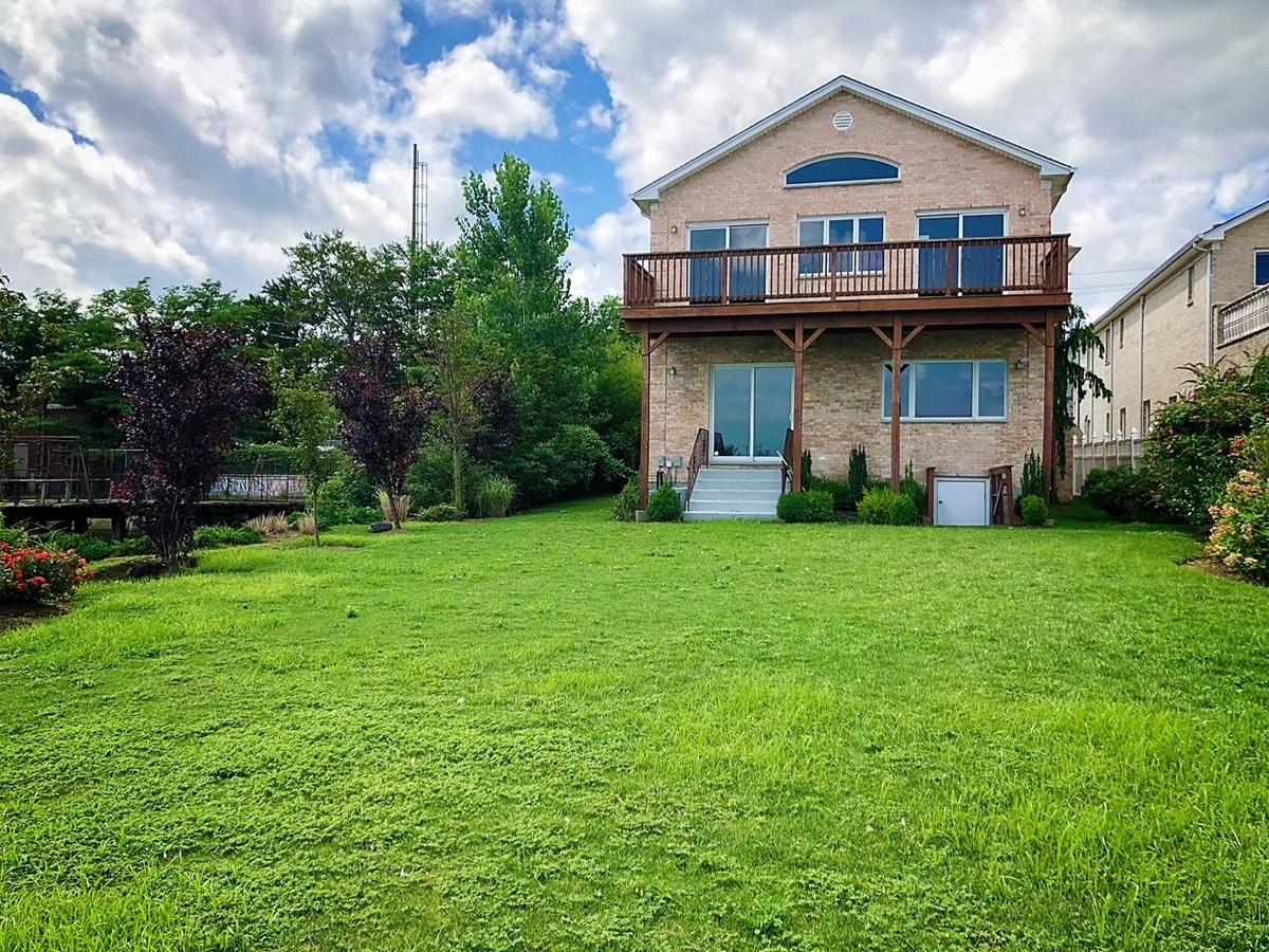 Rear view of house with brick siding and a yard