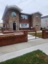 View of front facade with brick siding, stone siding, and a patio area