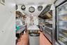 Kitchen with light tile patterned floors, stainless steel stove, and extractor fan