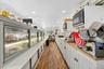 Kitchen featuring white cabinets, dark wood-style floors, recessed lighting, stainless steel microwave, and wood counters