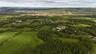 Aerial overview of property's location with a mountain backdrop and a forest
