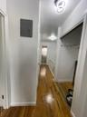 Corridor featuring wood finished floors and electric panel