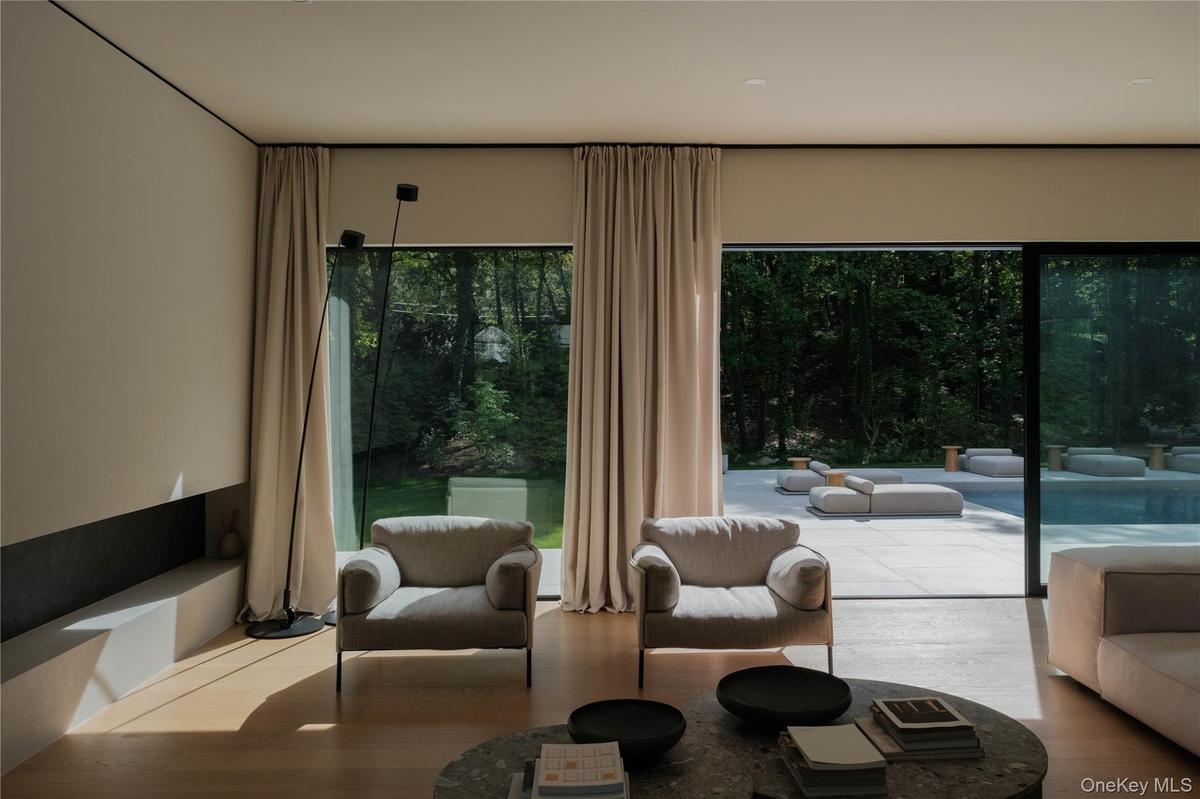 Living room with floor to ceiling marvin windows view to the backyard