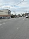 View of asphalt street featuring street lights and curbs