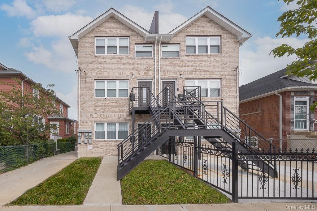 View of front of property featuring a fenced front yard, stairway, and brick siding