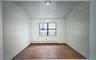 Empty room featuring lofted ceiling and a baseboard radiator