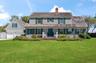 View of front of home featuring a front lawn, a chimney, and driveway