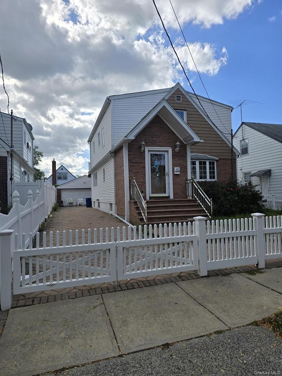 Bungalow-style house featuring brick siding and a fenced front yard