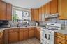 Kitchen featuring gas range gas stove, under cabinet range hood, light countertops, and decorative backsplash