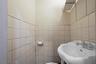 Half bath with tile walls and a sink