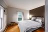 Bedroom with ornamental molding, hardwood / wood-style floors, and baseboard heating