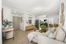 Living area with baseboards, light wood-style flooring, and a wall mounted AC
