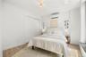 Bedroom featuring baseboards, a wall mounted air conditioner, a closet, and light wood finished floors
