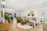 Living room featuring light wood-style floors and an AC wall unit
