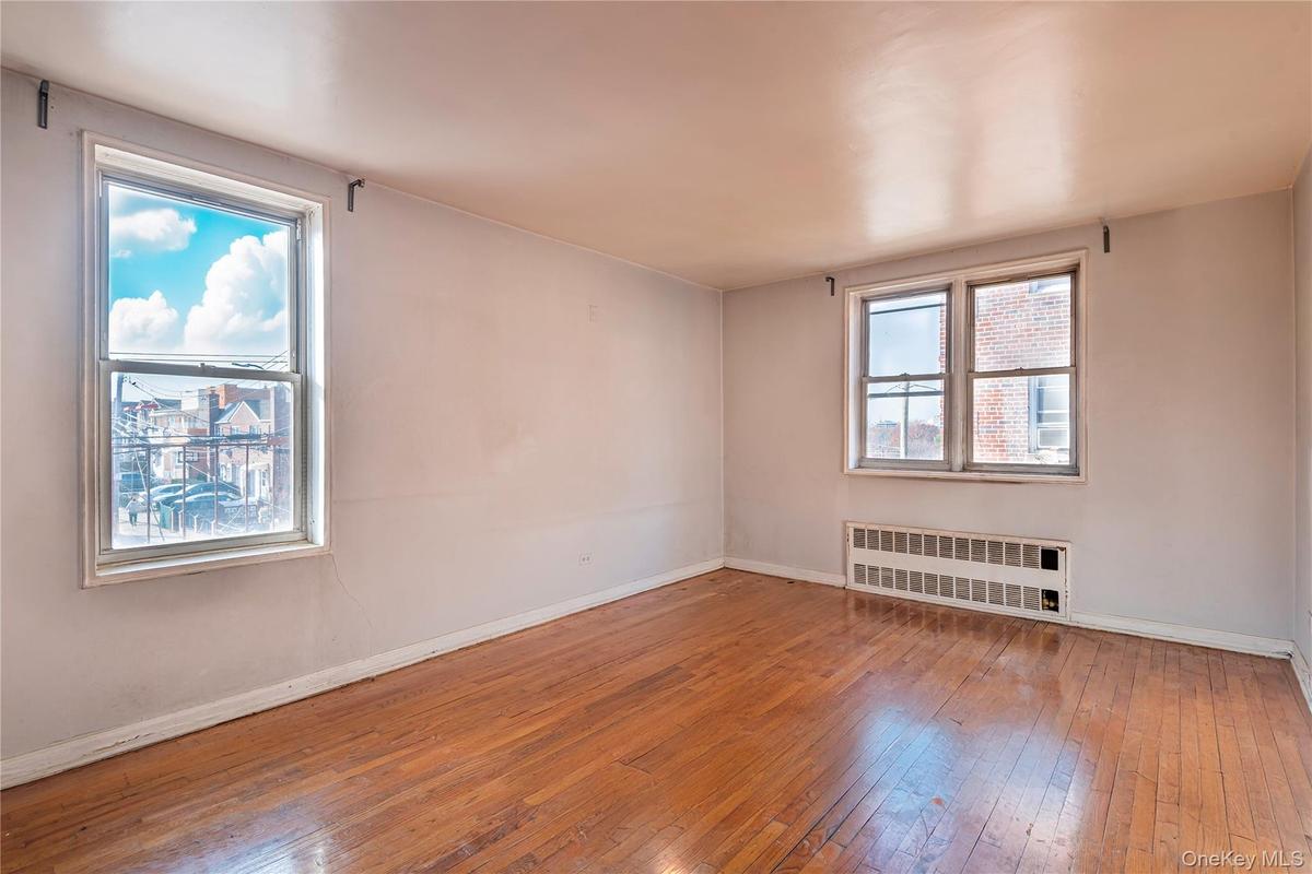 Unfurnished room with hardwood / wood-style flooring and radiator