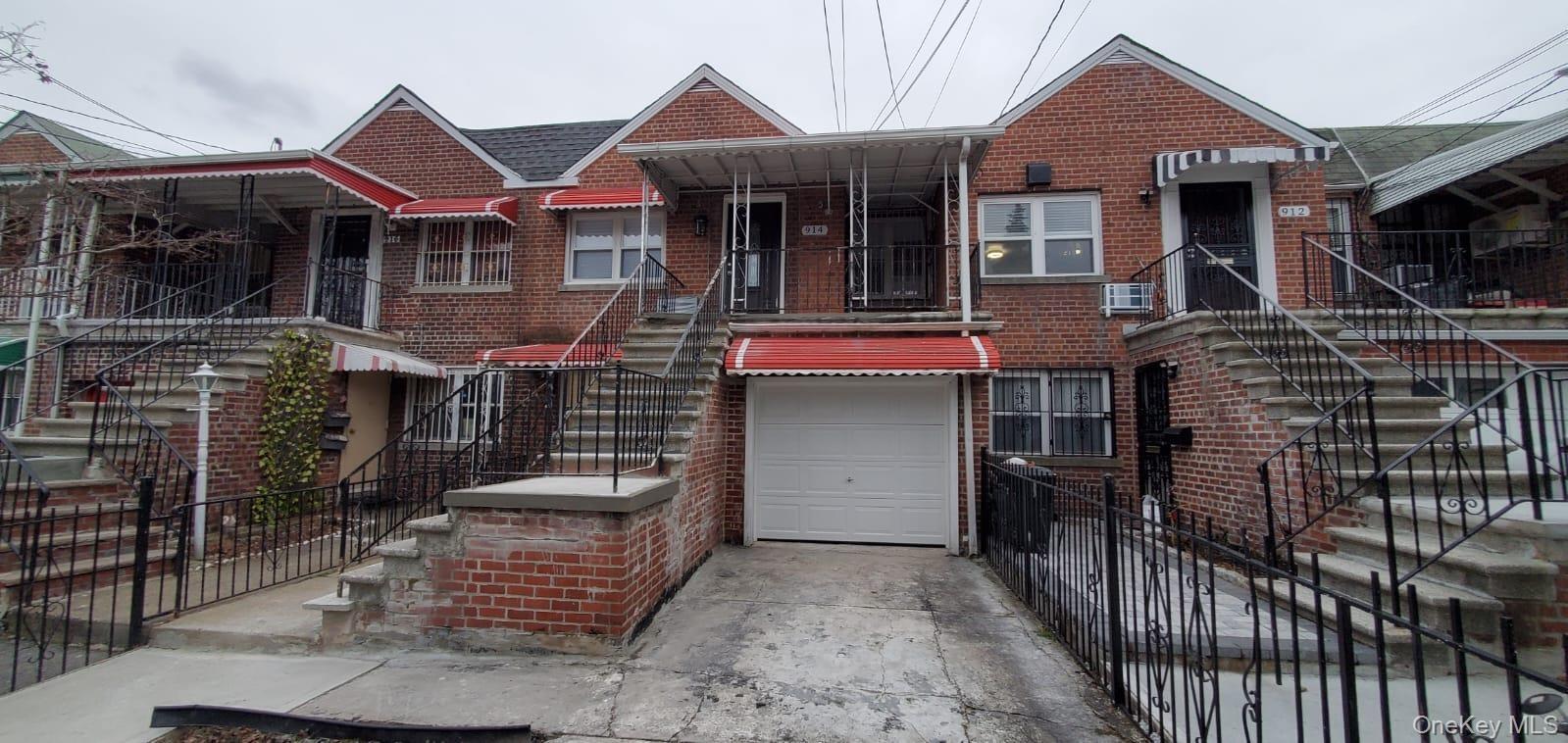 View of front facade with brick siding, a garage, stairway, and concrete driveway