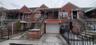 View of front facade with brick siding, a garage, stairway, and concrete driveway