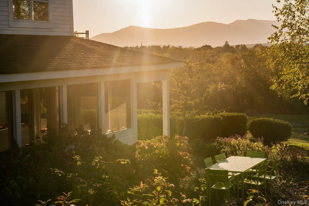 Property exterior at dusk featuring a mountain view and roof with shingles