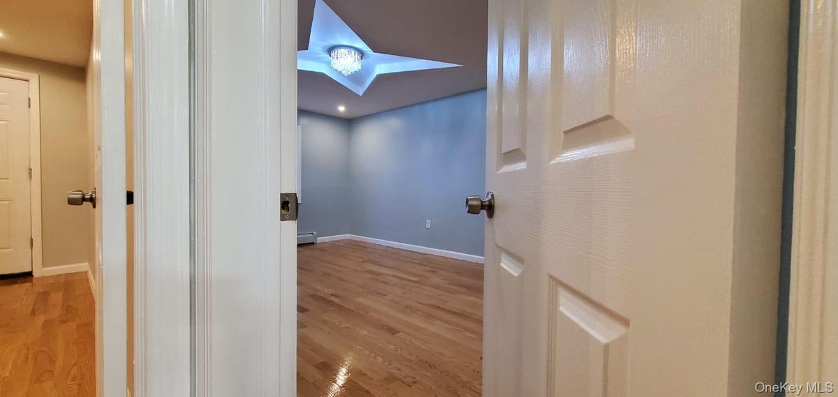 Corridor with wood finished floors and recessed lighting