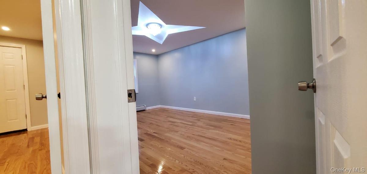 Corridor with a skylight, light wood-style flooring, and recessed lighting