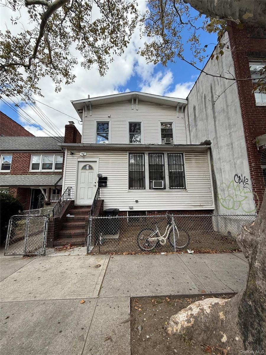 Rear view of house featuring a fenced front yard and a gate