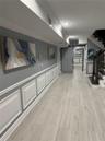Hallway with light hardwood / wood-style floors and crown molding