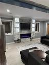 Living room with a large fireplace and ornamental molding