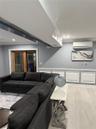 Living room with light wood-type flooring, a wall mounted AC, and crown molding