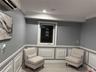 Living area featuring a wall unit AC, ornamental molding, and light hardwood / wood-style floors