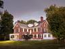 Back of property featuring a chimney, brick siding, and a lawn