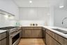 Kitchen with white cabinetry, sink, hanging light fixtures, and appliances with stainless steel finishes