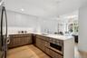 Kitchen with sink, light hardwood / wood-style flooring, decorative light fixtures, white cabinetry, and stainless steel appliances