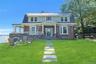 View of front of home standing copper roof sandstone siding front lawn