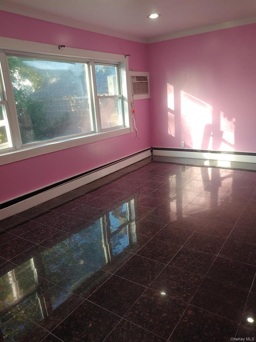 Spare room with granite floors, baseboard heating, a wall mounted AC, recessed lighting, and crown molding