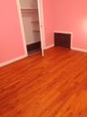 Unfurnished bedroom featuring dark wood finished floors, a closet, and heating unit