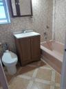 Full bathroom with tile walls, shower / bathtub combination, vanity, inlaid floor details, and tasteful backsplash