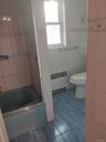 Bathroom with radiator, tile patterned flooring, tile walls, and shower / bathtub combination