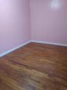 Spare room featuring dark wood-style floors and baseboards