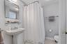 Full bathroom with a stall shower, tile walls, and light tile patterned flooring