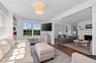 Living area featuring wood finished floors, radiator heating unit, and a fireplace